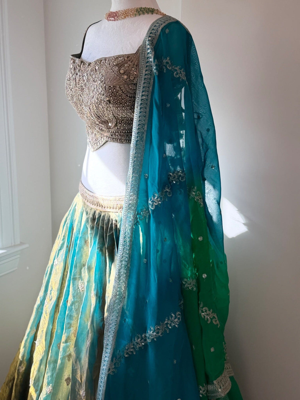 Original garment view of aqua and antique gold lehenga with embellished blouse and teal green dupatta