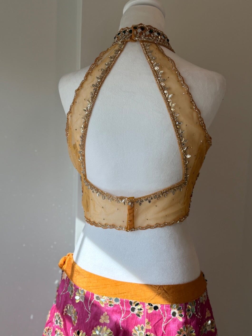 Open-back blouse detail of multicolored embellished halter lehenga rental set